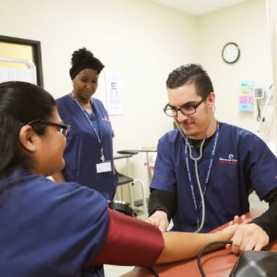 Nursing student practicing checking vitals on another student