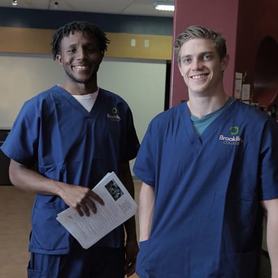 Two male nursing students in blue scrubs