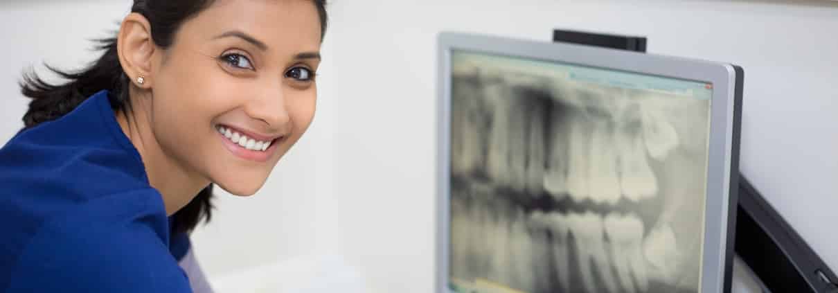 Smiling dental worker with an X-ray