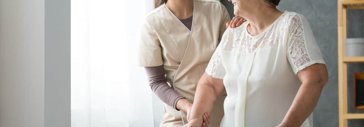 Caregiver helping a patient use her walker