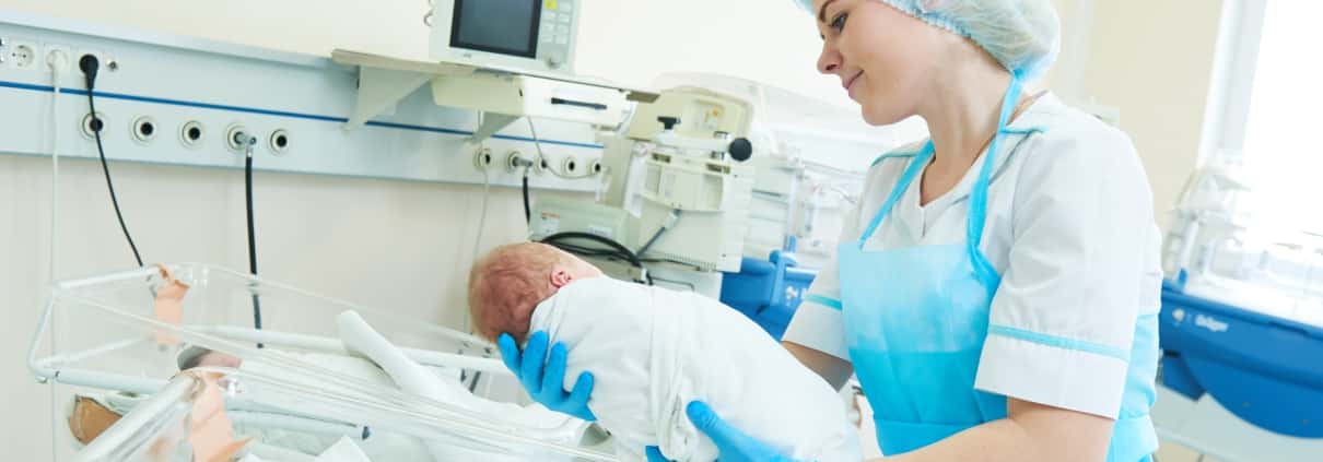 Neonatal nurse holding an infant