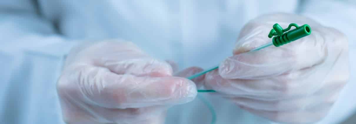 Gloved hands holding a catheter