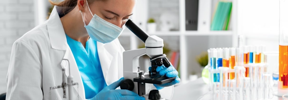 Young woman looking through a microscope