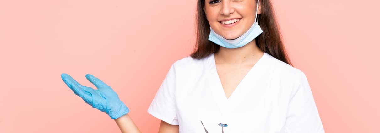 Female dental professional against a pink backdrop
