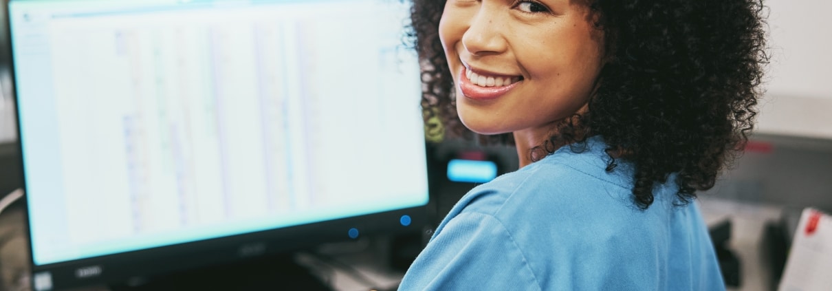 Smiling medical receptionist on the computer