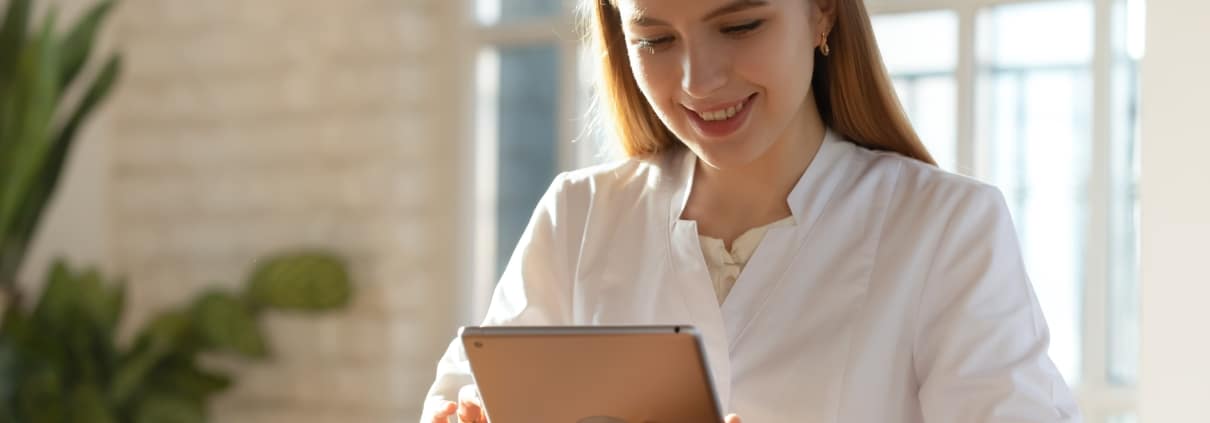 Smiling medical professional holding a tablet