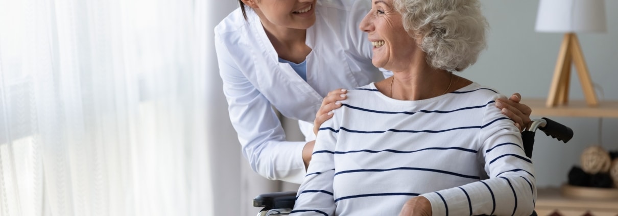 Smiling medical professional with an elderly patient in a wheelchair