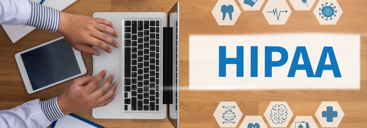 Aerial view of a man on a laptop and virtual symbols next to a sign that says HIPAA