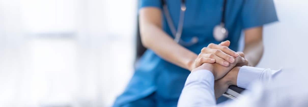 Close up of a medical professional consoling a patient