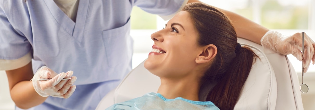 Young Dental Assistant with a smiling female patient