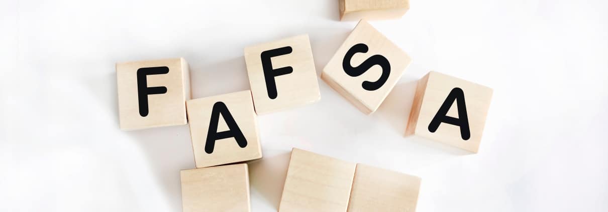 FAFSA is spelled in wooden blocks against a white background