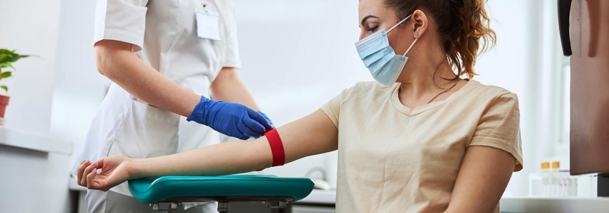 Phlebotomist drawing blood from a woman