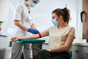 Phlebotomist drawing blood from a woman